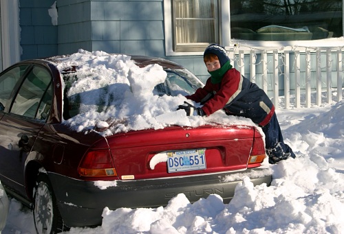 James clearing snow from the car